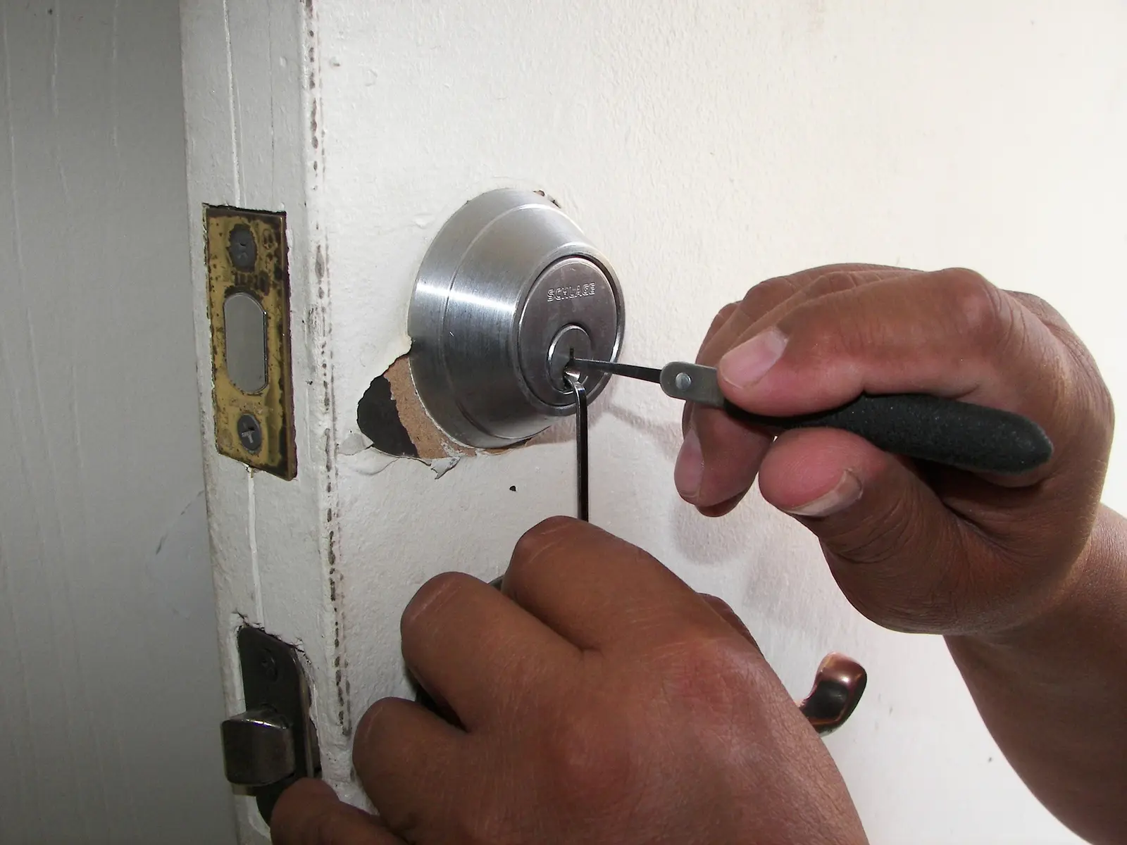 Un serrurier règle la serrure d'une porte d'entrée